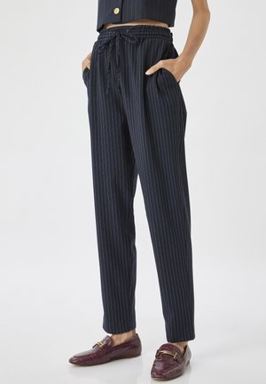 Marine-blauwe gestreepte broek met een elastische tailleband, zijzakken en een losse pasvorm. Soepele stof met verticale streepjes.