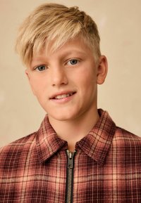 Rød og brun plaid zip-up jakke med kravehals og struktureret stof; har en fremtr�ædende lynlås foran.