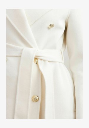 Palton alb din amestec de lână, cu un design tip wrap, având o curea legată în talie, nasturi aurii și o textură moale.