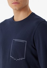 Dunkelblaues kurzärmeliges T-Shirt aus Baumwolle mit einem horizontal gestreiften Taschen-Design. Weiche Textur, runder Ausschnitt und eine figurbetonte Silhouette.