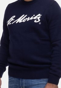 Maglione in maglia blu navy con orlo e polsini a coste, caratterizzato dal logo bianco "St. Moritz" sul petto. Texture morbida, design versatile.
