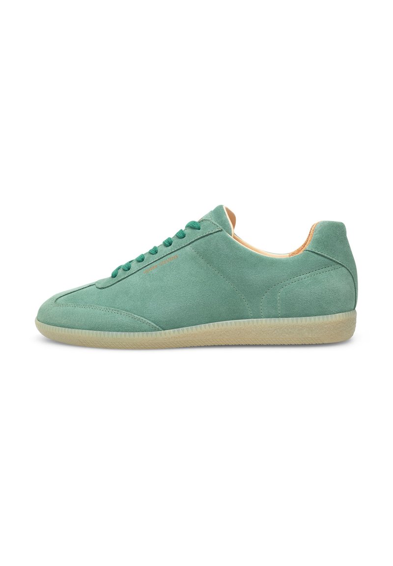 Sneaker verde in suede con punta arrotondata, lacci tonali e suola in gomma crema testurizzata. Presenta cuciture minime e un interno morbido.