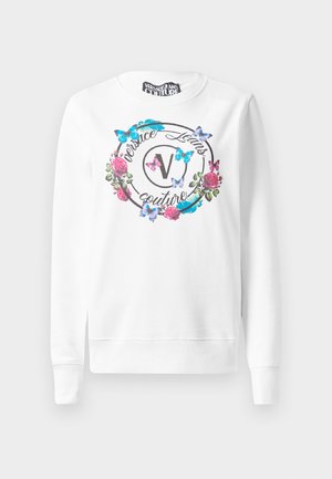 Sweatshirt blanc avec col rond, présentant un motif floral et de papillons autour d'un logo. Tissu en mélange de coton, avec des poignets côtelés aux manches.