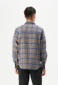 Plaid shirt in blue, orange, and yellow tones. Features a button-down collar, long sleeves, and a straight hem. Textured fabric.