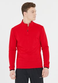 Rode langarm mid-layer top met een halve ritssluiting kraag, textuurstof, getailleerd ontwerp en contrasterende zwarte details bij de manchetten.