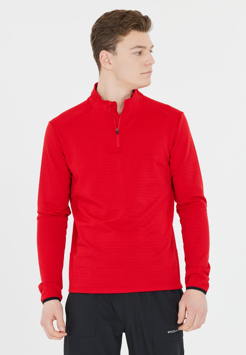 Rotes langärmeliges Mid-Layer-Top mit halblangem Reißverschlusskragen, strukturiertem Stoff, enganliegendem Design und kontrastierenden schwarzen Details an den Bündchen.
