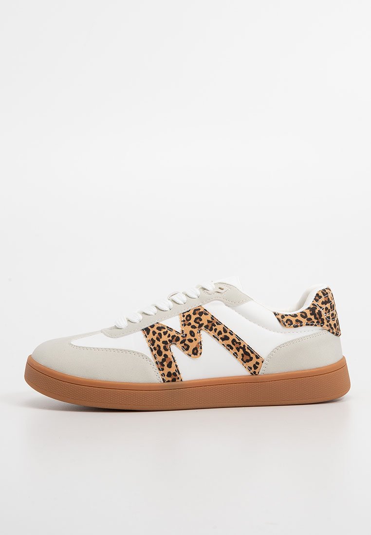 Zapatilla blanca con una punta en beige, detalles de estampado de leopardo y suela de goma. Diseño de cordones con un logo M en contraste.