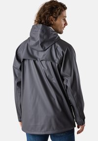 Veste imperméable grise avec capuche, présentant une coupe décontractée, une texture lisse et des boutons-pression à l'arrière pour la ventilation.