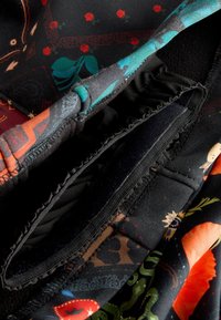 Többszínű szövet virág- és geometriai mintákkal. Tartalmaz fekete bélést, elasztikus szegélyt, valamint puha és sima textúrák kombinációját.