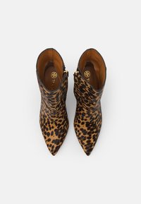 Paire de bottines à bout pointu avec motif léopard et fermeture éclair latérale, vue de dessus sur fond blanc.