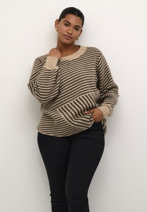 Striped sweater in beige and dark brown, with a wide neckline, dropped shoulders, and a loose fit. Black jeans with a slim fit.