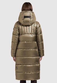 Lange donkergroene donzen jas met een hoge kraag en capuchon. Heeft horizontale stiksels en een logopatch bij de zoom. Gladde, glanzende textuur.