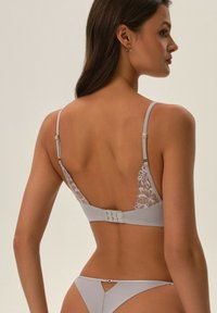 Szary zestaw bielizny składający się z biustonosza z koronkowymi wstawkami i regulowanymi ramiączkami oraz dopasowanego thongu z wycięciem z tyłu.