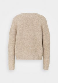 Beige strikket genser med avslappet passform, ribbet mansjetter og kant. Myk tekstur med et subtilt mønster gjennom stoffet.