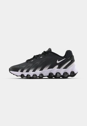 Black and gray athletic shoe with a sculpted design, textured upper, and distinct circular cushioning elements at the sole.