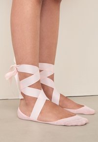 Ballerine rosa chiaro con nastri di raso alla caviglia, caratterizzate da un tessuto morbido e strutturato e un design con punta arrotondata.