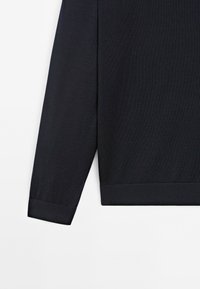 Maglietta a maniche lunghe blu scuro con una texture a coste e maniche a polsino. Presenta un orlo dritto e un motivo di tessuto sottile.
