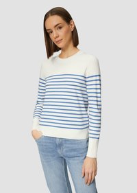 Weißer Pullover mit blauen horizontalen Streifen, Rundhalsausschnitt, langen Ärmeln und gerippten Bündchen. Kombiniert mit hellblauen Jeans.