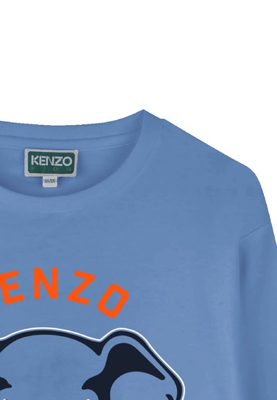 T-shirt en coton bleu clair avec un col rond. Présente un logo en orange et noir représentant le visage d'un éléphant. Étiquette indiquant "KENZO KIDS."