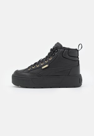 Sort Puma højt sneakers med tyk sål, gyldne øjensømme og polstret ankelkrave, vist fra siden på en ensfarvet baggrund.