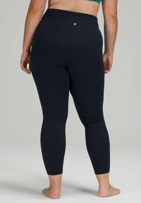 Leggings a vita alta blu navy realizzati in tessuto elasticizzato, caratterizzati da una texture liscia e un piccolo logo sul retro della vita.