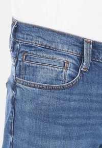 Los jeans de mezclilla azules cuentan con un bolsillo trasero con costuras naranjas en contraste, una textura suave y un diseño ceñido.