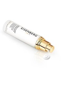 Hvid cylindrisk pumpeflaske med guld accenter, mærket "Eisenberg Paris," der dispenserer en lille svulp af hvid creme. Glat overflade, minimalistisk design.