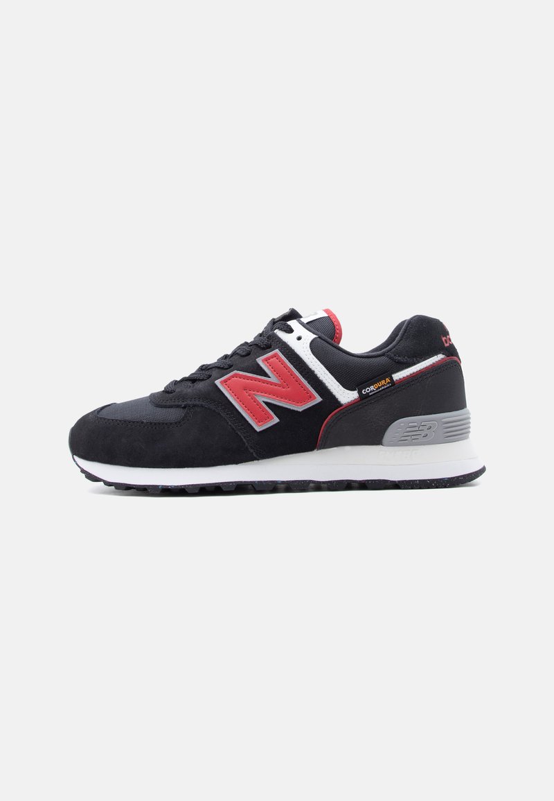 Pantof sport New Balance negru și roșu cu talpă medie albă, etichetă din material Cordura și talpă exterioară din cauciuc texturat, prezentat în profil lateral drept pe fundal alb.