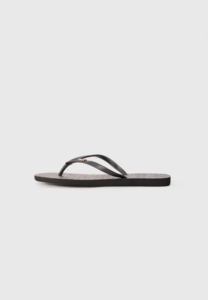 Tongs noires en plastique avec des brides en caoutchouc lisses, présentant une semelle intérieure noire texturée et un subtil accent doré sur la bride.