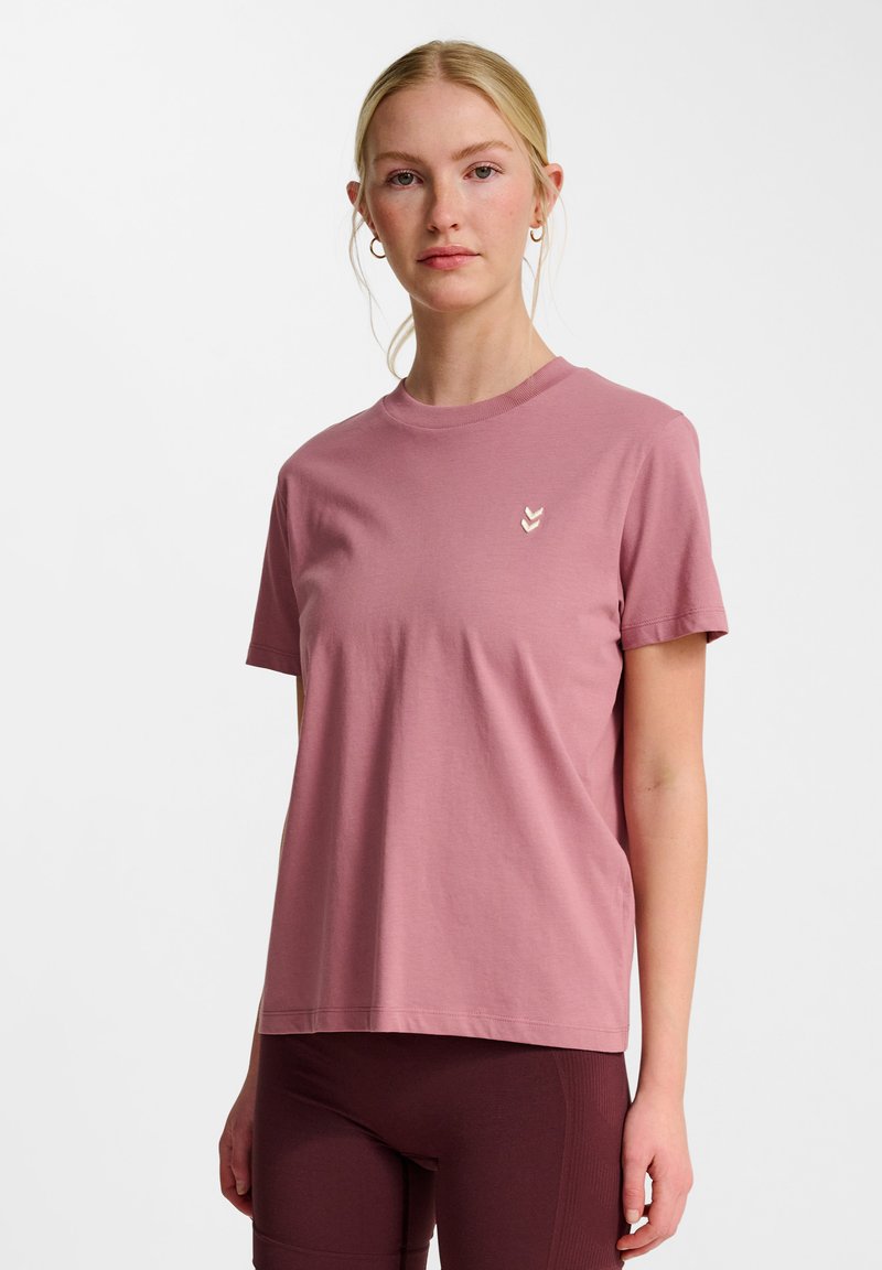 Kortærmet T-shirt med rund hals i lys pink bomuld. Har et lille tre-chevrons logo i nedtonede farver på brystet.