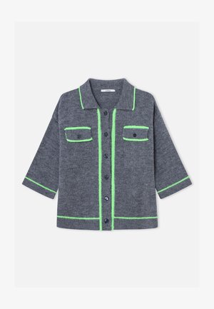 Siv pleteni pulover z ovratnikom, z zelenimi poudarki ob robovih in žepih ter temnimi gumbi spredaj.