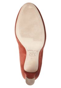 Bruna mockaskinn med hög klack, en texturerad gummisula och rundad tå. Har en metallisk klackdetalj och stämplad logotyp på innersulan.