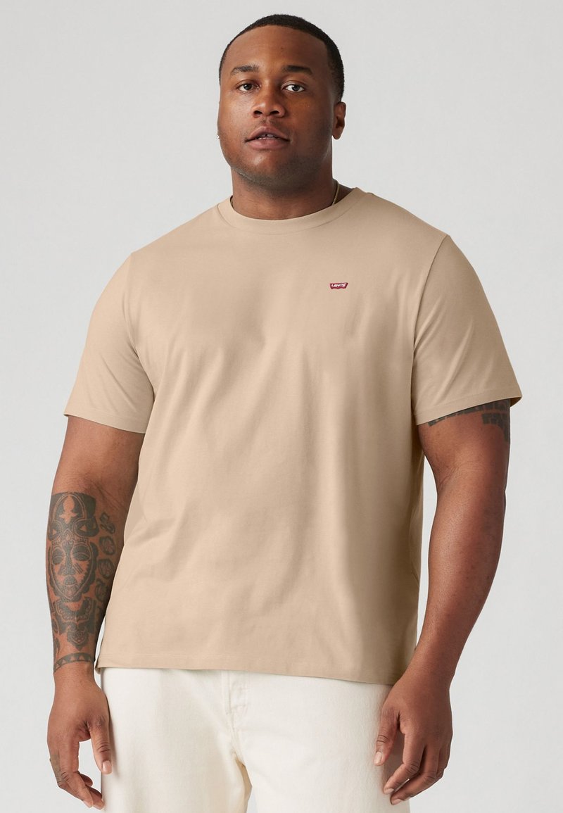 Beige pamut póló rövid ujjakkal és kerek nyakkivágással. A felső mellrészen egy kisméretű piros Levi's logó található. Sima textúrájú.