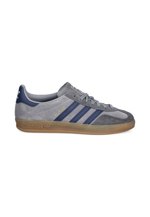 Sneaker Adidas Gazelle grigia con strisce blu navy, suola in gomma, texture in camoscio e scritta dorata "GAZELLE" sul lato.