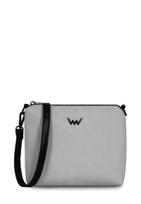 Šedá plátěná crossbody taška s černým koženým popruhem, s černým logem na přední straně a hladkým, strukturovaným povrchem.