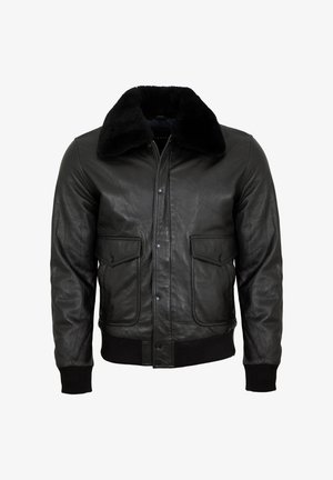Schwarze Leder-Bomberjacke mit einem flauschigen schwarzen Lammfellkragen. Verfügt über vordere Druckknopftaschen und gerippte Bündchen. Glatte Textur durchgehend.