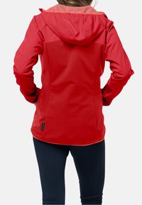 Giacca softshell rossa con cappuccio, con esterno liscio, parte superiore della schiena texturizzata e design aderente. Include un'etichetta all'orlo.