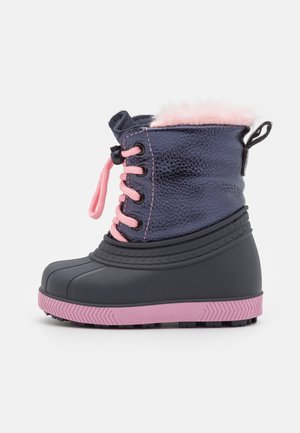Botte d'hiver pour enfants avec tige texturée bleu marine, lacets roses, doublure en fourrure rose, partie inférieure en caoutchouc noir et semelle à crampons rose, vue de profil.