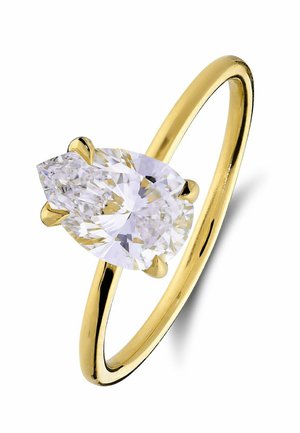 Gouden ring met een peer-vormige heldere diamant die wordt vastgehouden door drie pootjes op een eenvoudige dunne band tegen een witte achtergrond.