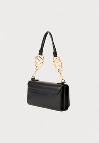 Schwarze Lederhandtasche mit umklappbarem Design, goldfarbenen Kettenakzenten und strukturiertem Schultergurt. Verfügt über eine Rückentasche für zusätzliche Funktionalität.