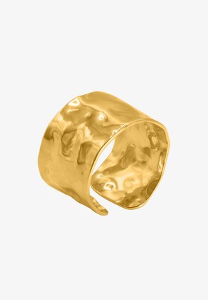 Velký, kovaný zlatý náramek s lesklým povrchem; nepravidelný, vlnitý povrch a otevřený design pro nastavitelné nošení.