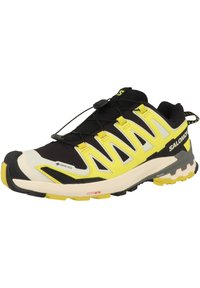 Zapatilla de trail running en negro y amarillo con parte superior de malla, etiqueta GORE-TEX, detalles reflectantes y suela Contagrip para tracción.