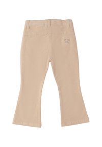 Pantalons beiges pour tout-petits avec jambes évasées, passants de ceinture et petit cœur en strass près de la poche arrière droite.