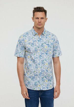 Chemise à manches courtes avec boutons en tissu blanc, ornée d'un motif floral bleu et jaune. Dotée d'un col classique et d'une coupe décontractée.