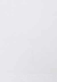 Vitt bomullstyg med en slät textur, som har en subtil stretch och en rak fåll. Inga mönster eller utsmyckningar synliga.