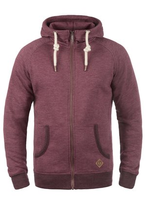 Felpa con zip color mogano, con lacci color crema, tasche laterali e bordi marroni. Realizzata in tessuto testurizzato e presenta un piccolo logo nella parte anteriore inferiore.