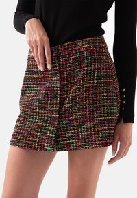 Tweed shorts met een multicolore patroon in tinten van zwart, groen, roze en oranje, versierd met zwarte knopen aan één kant.