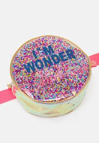 Borsetta rotonda con corpo trasparente iridescente, glitter multicolore all'interno e testo "I'M WONDER" in blu navy e "Billieblush" in rosa.