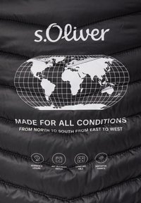 Der Stoff der schwarzen Steppjacke zeigt eine weiße Weltkarten-Grafik, Logotext und Symbole, die Vielseitigkeit und Stoffinnovation hervorheben.