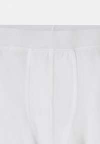 Vita bomullsboxershorts med mjuk midja, med en slät yta och en central söm för struktur, designade för komfort.